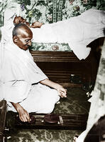 Mahatma Gandhi spinning in the cabin of Pundit Madan Mohan Malaviya (seen in background) on board of S.S. Rajputana during his voyage to England, Bombay, August 1931. [AKG110392628]