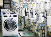 A worker inspects the functioning of smart washers rolling off the production line at a Haier factory in Qingdao in east China's Shandong province Sunday, Feb. 18, 2024. [PST110004175]