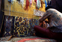 Man weaving a gold carpet using fine gold wire and a raised silk design. This was a commission for the president of Lufthansa Airlines. Tehran, Iran. [PST110004225]