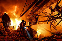 A rescuer works to extinguish a fire at a residential property damaged in a Russian drone attack in Zaporizhzhia, Ukraine, on March 16, 2026. [PST110004295]