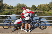 England, Hampshire, River Test at Leckford, Colourful Cyclists and Test River [STV110083969]