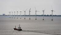 Cargo ship sailing in front of an offshore wind farm in the Øresund outside Copenhagen, Denmark, Europe [TPG110085115]