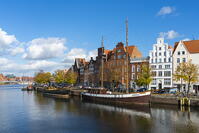 Boats anchored on Trave river and houses with traditional gables in background, Lubeck, UNESCO, Schleswig-Holstein, Germany [AWL110001670]