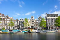 Boats moored in Singel canal near typical houses against sky, Amsterdam, Netherlands [AWL110002037]