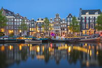 Boats moored in Singel canal near typical houses at twilight, Amsterdam, Netherlands [AWL110002042]