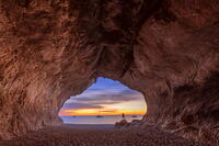 Lonely person looks colors of the sunrise inside the sea cave on the beach of Cala Luna, Baunei, Ogliastra province,  Sardinia, Italy (MR) [AWL110002084]