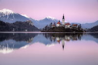 Church of the Assumption of the Blessed Virgin Mary, on Bled island, Lake Bled, at dusk, in winter, with the Julian Alps in the distance, Bled, Slovenia [AWL110002111]