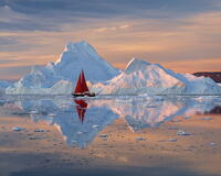 Red sailboat at sunset near icebergs in Disko Bay, Greenland [AWL110002114]