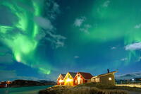 Traditional rorbu hit by Northern Lights in winter, Sommaroy, Troms og Finnmark, Norway [AWL110002472]