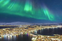 Glowing Northern Lights in the night sky over Tromso city and fjord, Norway [AWL110002474]