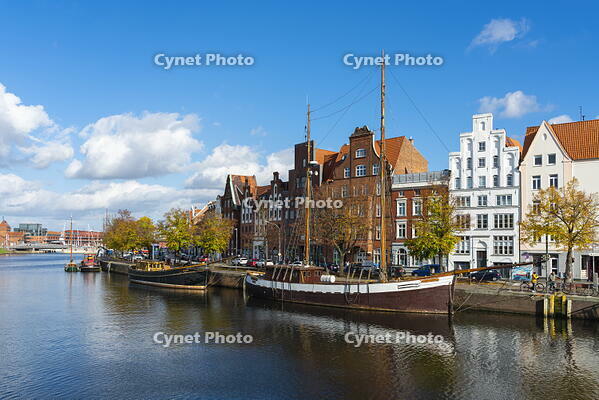 Boats anchored on Trave river and houses with traditional gables in background, Lubeck, UNESCO, Schleswig-Holstein, Germany [AWL110001670]