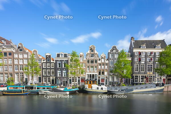 Boats moored in Singel canal near typical houses against sky, Amsterdam, Netherlands [AWL110002037]