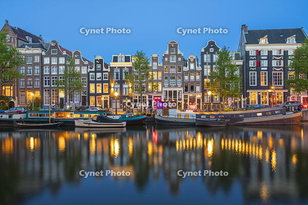 Boats moored in Singel canal near typical houses at twilight, Amsterdam, Netherlands [AWL110002042]