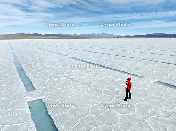 Aerial view of a person looking at the turquoise pools of the Salinas Grandes Salt Flat, Puna de Atacama, Jujuy, Argentina. [AWL110002073]