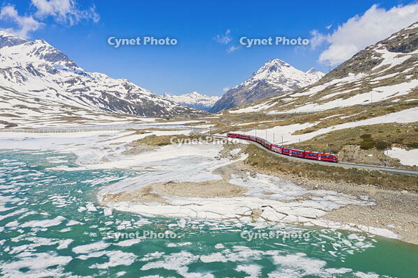 Bernina Express train at Lago Bianco during thaw, Bernina Pass, canton of Graubunden, Engadine, Switzerland [AWL110002171]