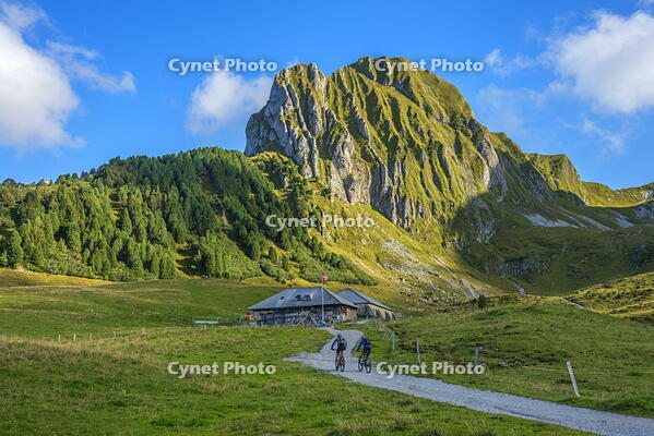 Mountain biker in front of Gantrisch hut and N?nenflue, Berner Alps, Bern, Switzerland [AWL110002199]