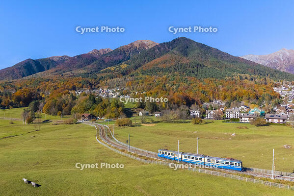 The Vigezzina-Centovalli train passes near the town of Santa Maria Maggiore in the autumnal colors of foliage. Valle Vigezzo, val d'Ossola, Verbano Cusio Ossola, Piedmont, Italy. [AWL110002237]