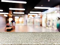 Marble board empty table in front of blurred background. Perspective marble table over blur in shopping mall hall. Mock up for display or montage your product [IBR122665451]
