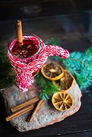 Mulled wine in a glass and christmas time decorations on rustic wooden table [IBR123380121]
