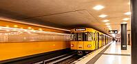 Dynamic scene of a Berlin underground in typical yellow colour, long exposure with blur effect, busy traffic junction at Unter den Linden station, Berlin, Germany [IBR112672610]