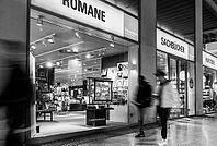 Black and white photograph, Dussmann GmbH, bookshop, urban scene in the evening with reflections in the window pane and a view of the displays and shelves, Berlin, Germany [IBR112672616]
