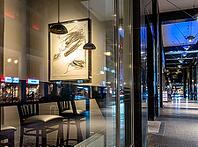 Urban scene in the evening with reflections of Friedrichstraße in the window pane of a bistro, Berlin, Germany [IBR112672620]