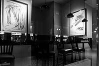 Black and white photograph, urban scene in the evening with reflections of Friedrichstraße in the window pane of a bistro, Berlin, Germany [IBR112672621]