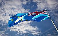 Beautiful national state flag of Tuvalu fluttering at sky background. Low angle close-up Tuvalu flag 3D artwork [IBR123569290]