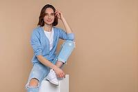 Smiling fashion woman in casual clothing looking at camera with happy face empty space isolated over beige background [IBR123569310]