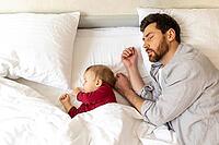 Father and little baby sleeping together in bed, parenthood, newborn daughter [IBR123569317]