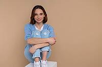 Confident attractive woman in casual clothing looking at camera isolated over beige background [IBR123569335]