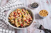 A bowl of cooked rice and vegetables for garnish on the table [IBR123629689]