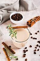 Cup of iced latte with rosemary and cinnamon on the table vertical view [IBR123629693]