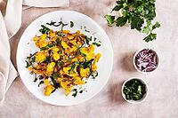 Baked small cauliflower steaks with onions and herbs on a plate on the table top view [IBR123629695]