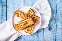 Close up of appetizing croutons in powdered sugar on a plate on the table top view [IBR123629697]