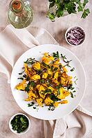 Baked spicy cauliflower with onions and parsley on a plate on the table top and vertical view [IBR123629706]