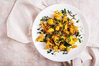 Close up of baked small cauliflower steaks with onions and herbs on a plate on the table top view [IBR123629709]