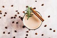 Close up of aromatic coffee with rosemary and cinnamon in a glass on the table top view [IBR123629711]