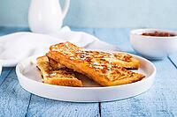 Appetizing croutons in powdered sugar on a plate on the table [IBR123629712]