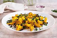 Baked small cauliflower steaks with onions and herbs on a plate on the table [IBR123629718]