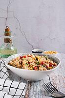 Homemade fried rice with peas, corn and pepper in a bowl on the table vertical view [IBR123629722]