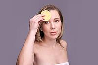 Caucasian female adult skincare routine with natural sponge on grey background [IBR123629762]