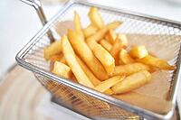 Basket with french fry. Potato chips. Cooking uhealthy lunch. Salty spicy junk. Oil takeaway gastronomy [IBR123638352]