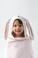 Smiling child wrapped in soft pink towel with bunny ears, looking directly at camera against a white background. hood has an embroidered rabbit face, creating a cute and cozy appearance, vertical [IBR123638381]