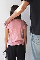 Vertical photo, child girl and man from behind, adult man's hand on child's shoulder, concept of child abuse, kidnapping and violence against children [IBR123638385]