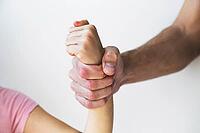 A strong adult hand tightly gripping a child's wrist, symbolizing domestic violence, abuse, and lack of freedom [IBR123638386]