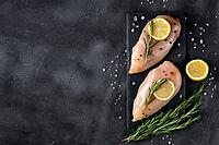 Raw fresh chicken fillet with rosemary, lemon and spices on a dark background. Food background, cooking ingredients. Top view with copy space [IBR123639513]