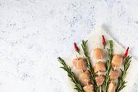 Raw chicken kebabs and rosemary in the form of a bouquet on a light background. Food background, cooking ingredients. Top view with copy space [IBR123639514]