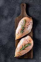 Raw fresh chicken fillet with rosemary and spices on a dark background. Food background, cooking ingredients. Top view [IBR123639516]
