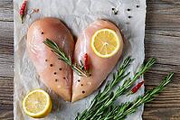 Raw chicken fillet in the shape of a heart with rosemary and spices on natural wooden background. Top view [IBR123639518]